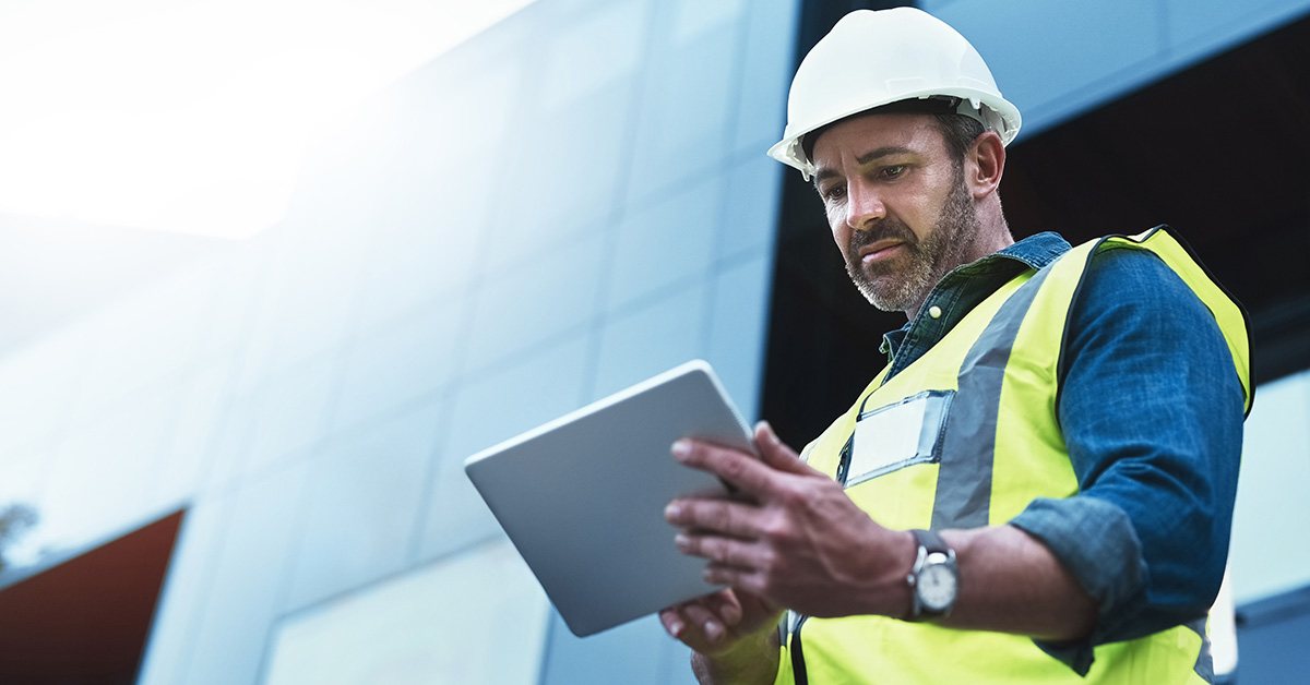 construction worker entering data on tablet