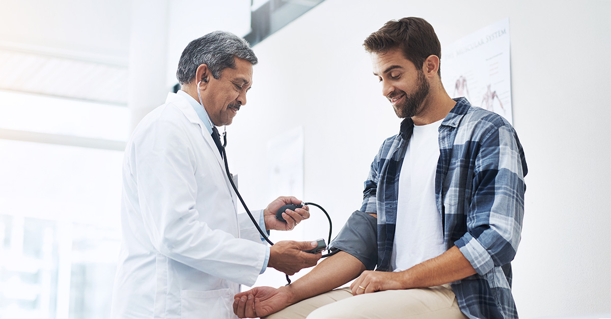 A man getting his blood pressure checked by a doctor