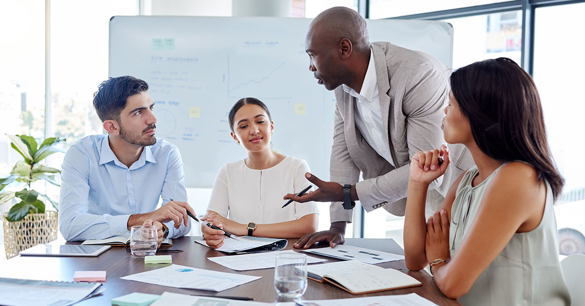 group of employees at a table discussing metrics